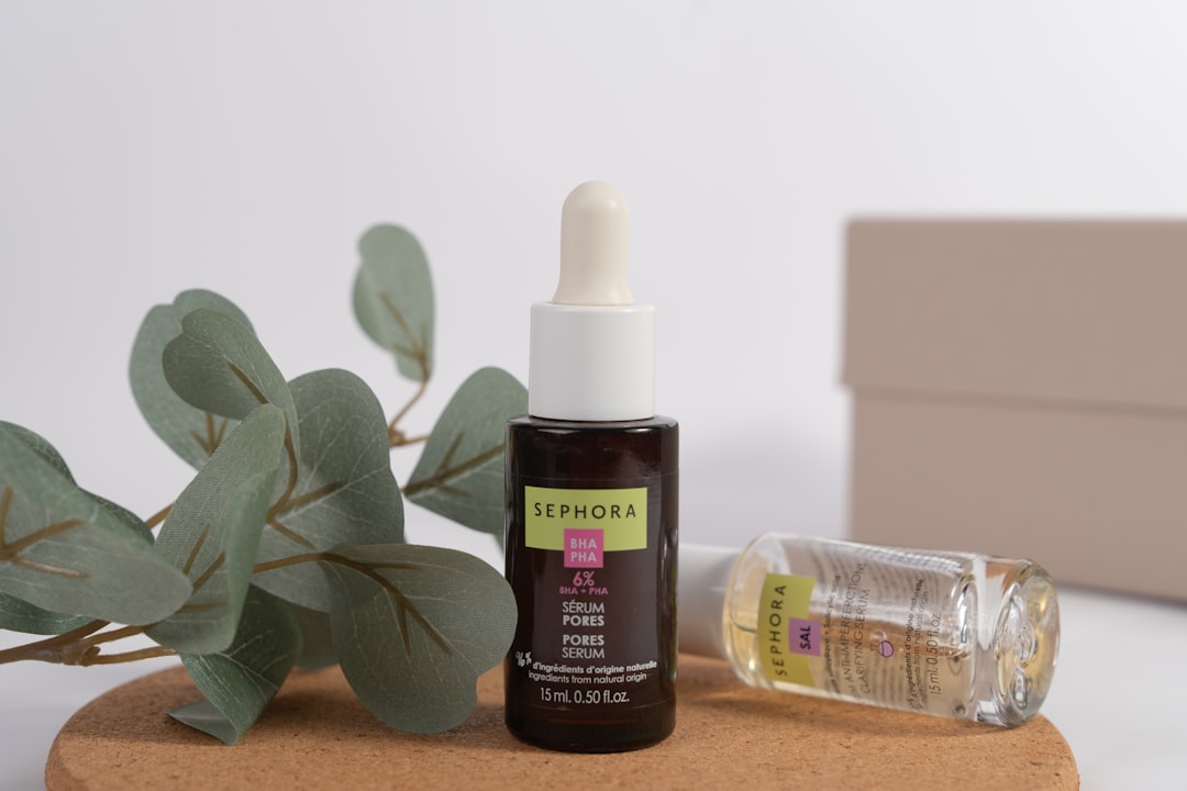 A bottle of essential oil next to a plant
